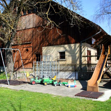 Der Spielplatz und der weitläufige Aussenbereich ist ein Paradies für die Kinderwelt. Diverse Traktoren, Töggelikasten und ein Pingpongtisch mit Schlägern stehen auf Anfrage bereit. 